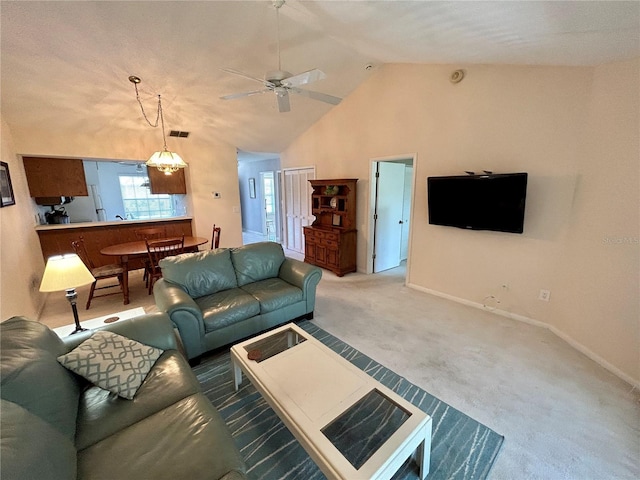 living room featuring ceiling fan with notable chandelier, carpet flooring, and high vaulted ceiling