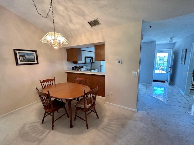 carpeted dining area featuring a textured ceiling and a chandelier