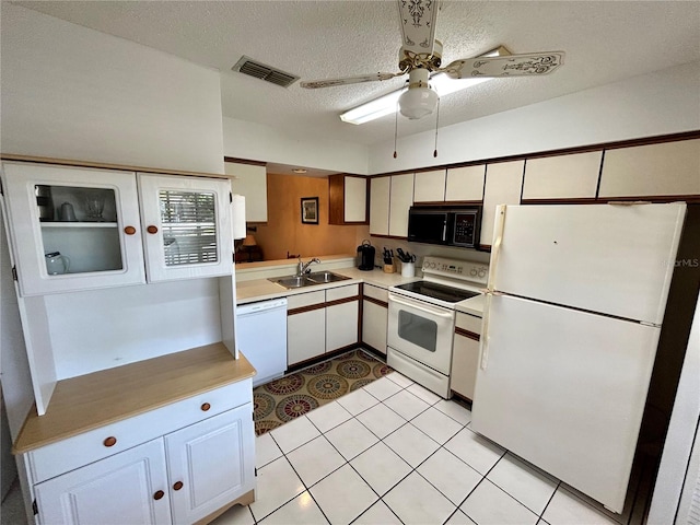 kitchen featuring white appliances, ceiling fan, light tile flooring, and white cabinetry