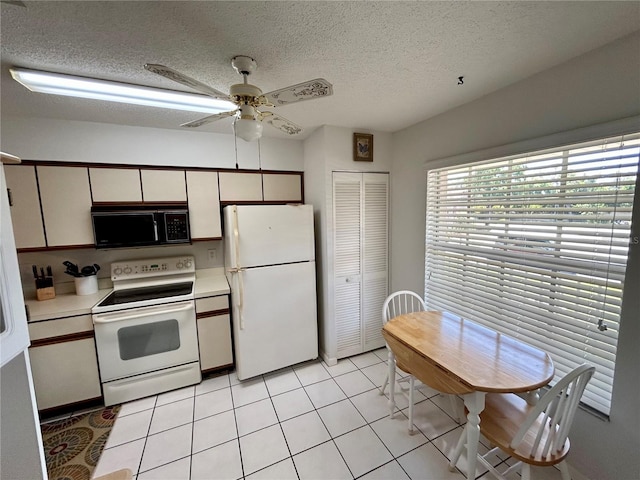 kitchen with ceiling fan, light tile floors, a textured ceiling, white cabinets, and white appliances