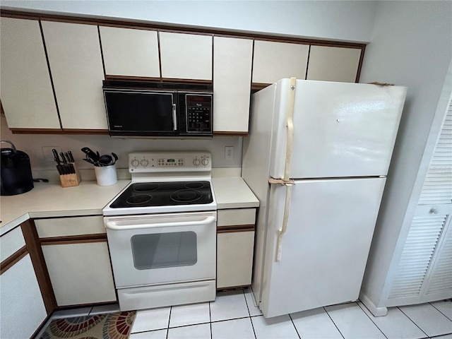 kitchen with white appliances, light tile floors, and white cabinetry