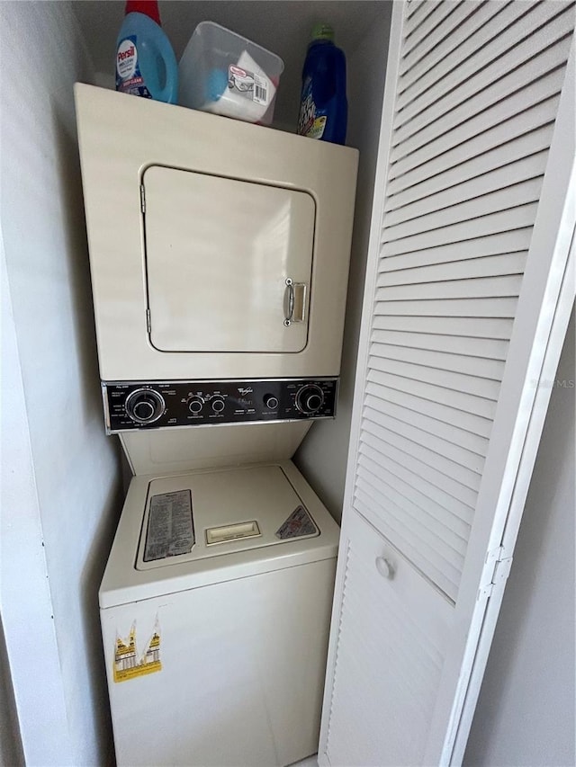 washroom featuring stacked washer and clothes dryer