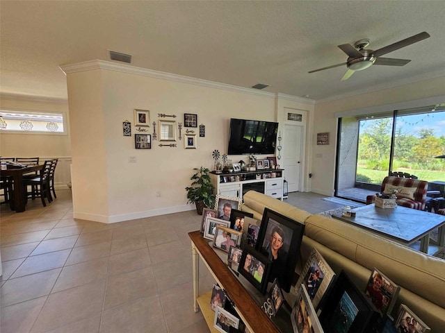 tiled living room with a textured ceiling, ceiling fan, and crown molding