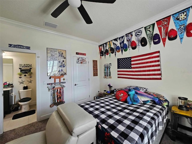 bedroom featuring ceiling fan, ornamental molding, a textured ceiling, and ensuite bath