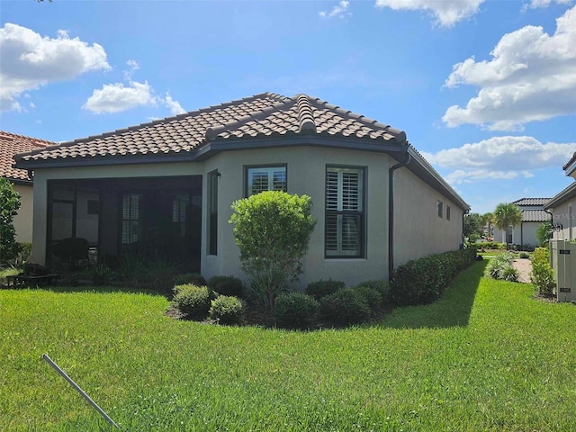 view of side of home with a yard