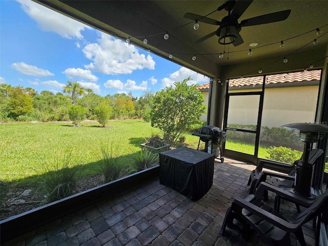 unfurnished sunroom with ceiling fan