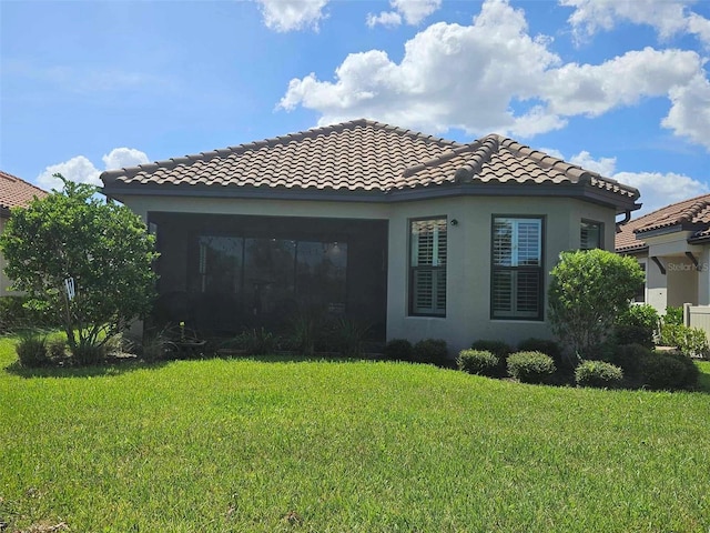 exterior space with a lawn, a tile roof, and stucco siding