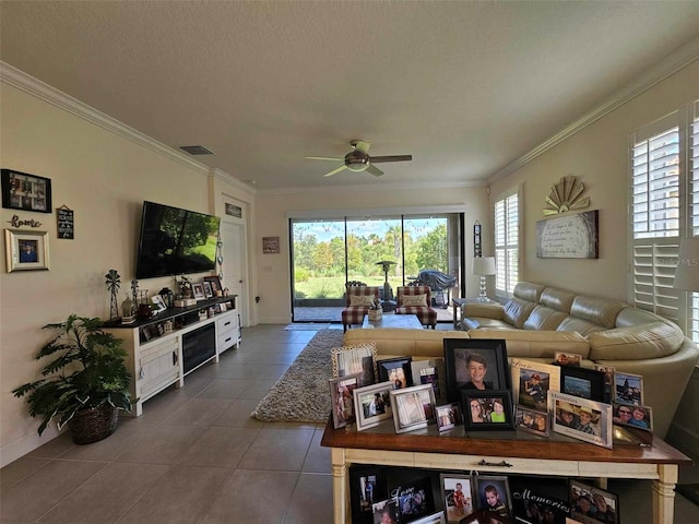 living room featuring a textured ceiling, dark tile patterned floors, visible vents, and ornamental molding