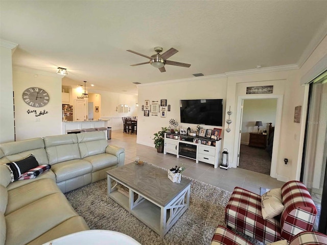 tiled living area with visible vents, baseboards, ceiling fan, and ornamental molding