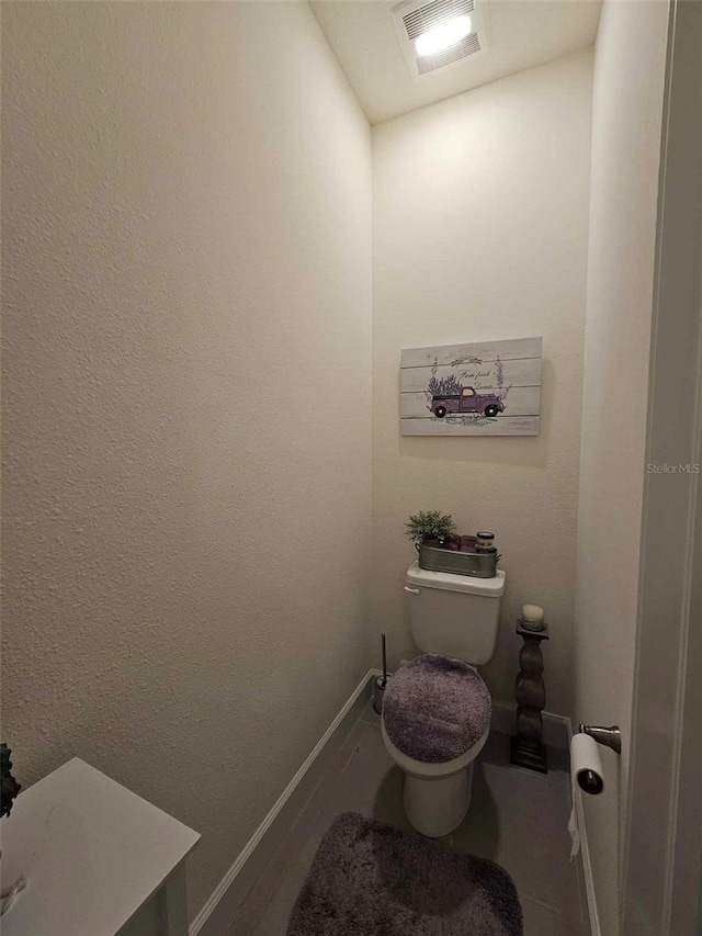 bathroom with wood finished floors, toilet, baseboards, and visible vents