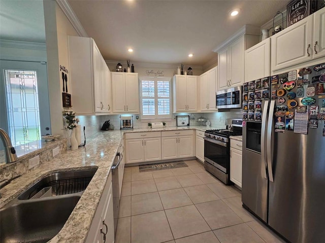 kitchen featuring a sink, tasteful backsplash, appliances with stainless steel finishes, light tile patterned flooring, and crown molding