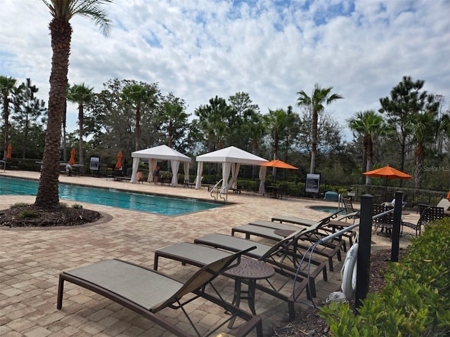 community pool with a patio and fence