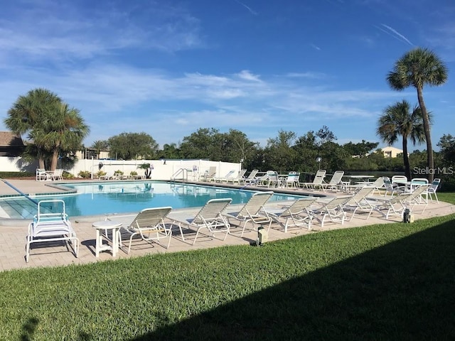 view of pool featuring a patio area and a yard