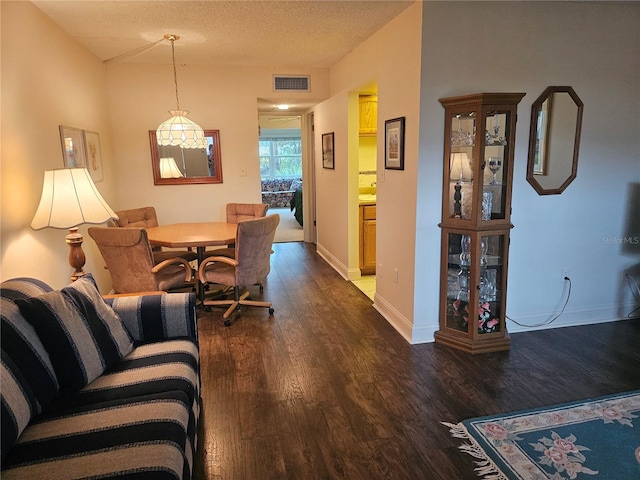 living room featuring a textured ceiling and dark hardwood / wood-style floors