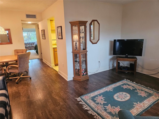 living room featuring a textured ceiling and dark hardwood / wood-style flooring