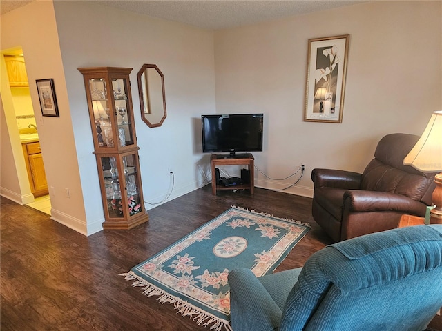 living room with a textured ceiling and dark hardwood / wood-style flooring