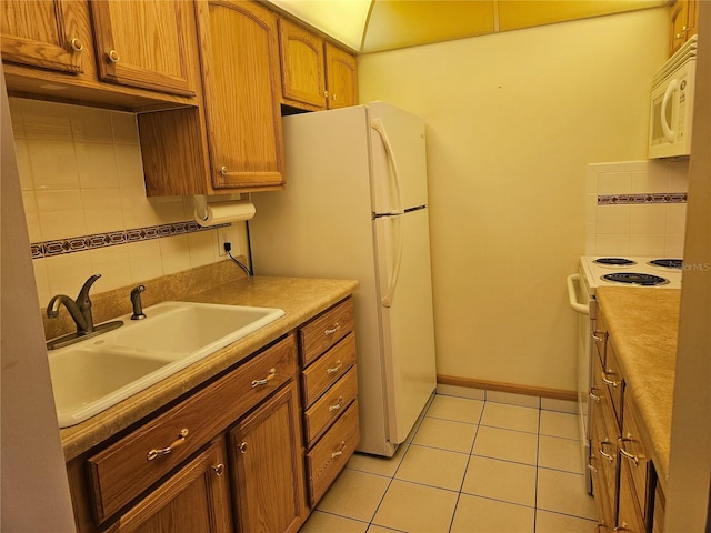 kitchen with backsplash, light tile floors, white appliances, and sink