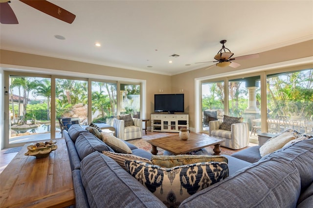 living room featuring crown molding, a healthy amount of sunlight, and ceiling fan