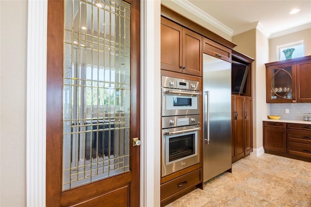 kitchen featuring light tile floors, tasteful backsplash, appliances with stainless steel finishes, crown molding, and a healthy amount of sunlight