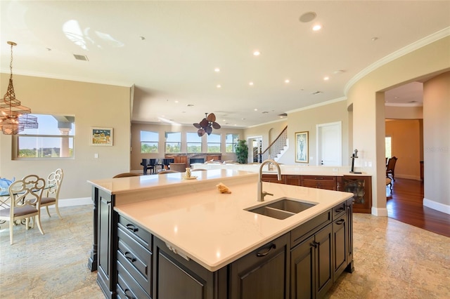 kitchen with hanging light fixtures, a kitchen island with sink, sink, light tile floors, and a chandelier