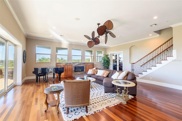 living room featuring light hardwood / wood-style floors, ceiling fan, and ornamental molding