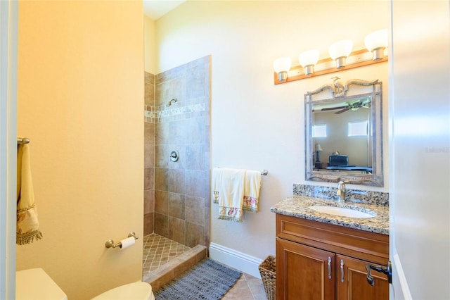 bathroom with oversized vanity, toilet, a tile shower, and tile floors