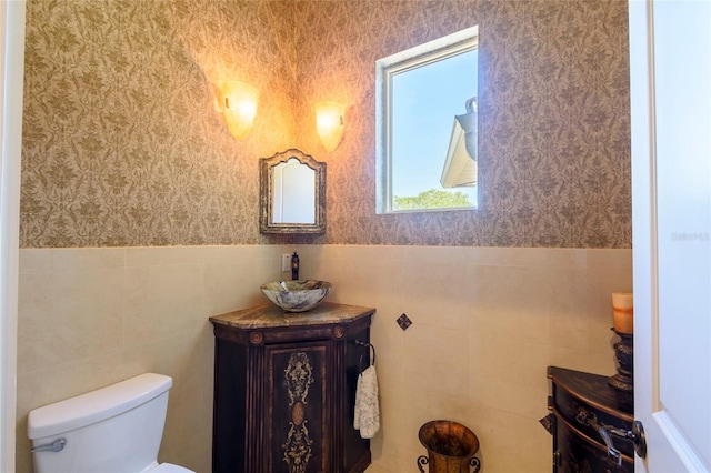 bathroom featuring tile walls, toilet, and vanity