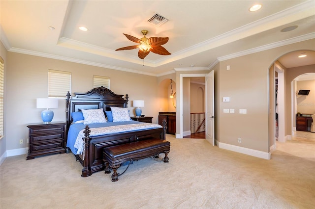 carpeted bedroom with ceiling fan, crown molding, and a raised ceiling