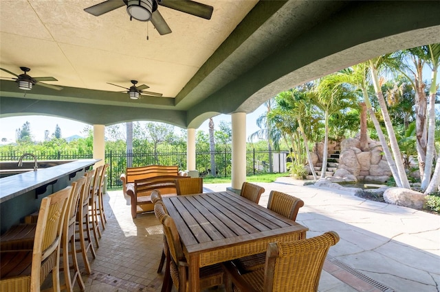 view of terrace with a bar, ceiling fan, and an outdoor hangout area