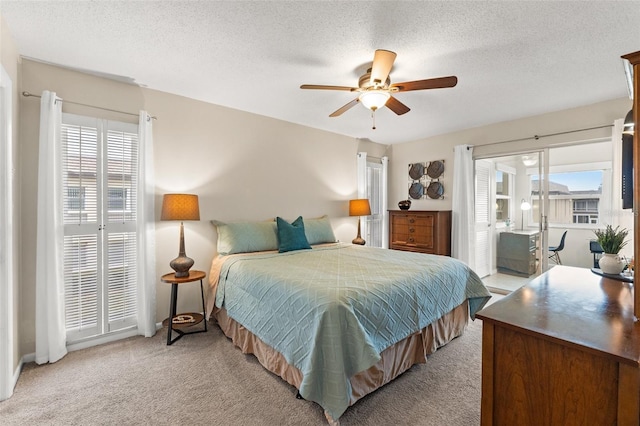 carpeted bedroom featuring multiple windows, a textured ceiling, and ceiling fan