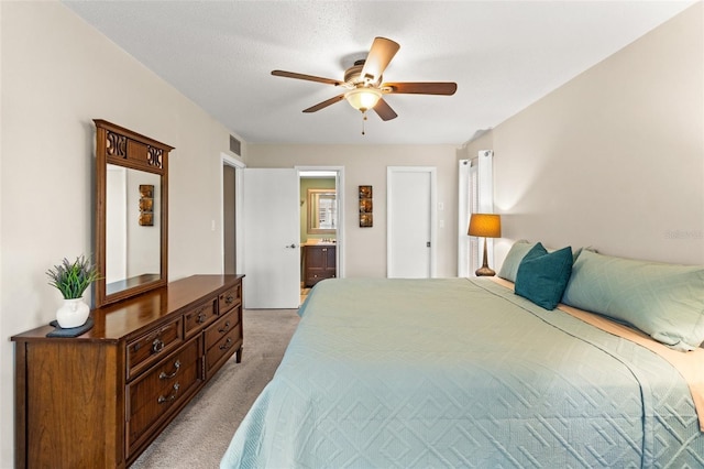 carpeted bedroom featuring connected bathroom, a textured ceiling, and ceiling fan