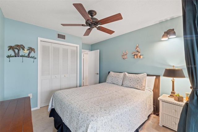 carpeted bedroom featuring ceiling fan and a closet