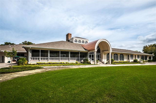 view of front of home with a front lawn and a sunroom