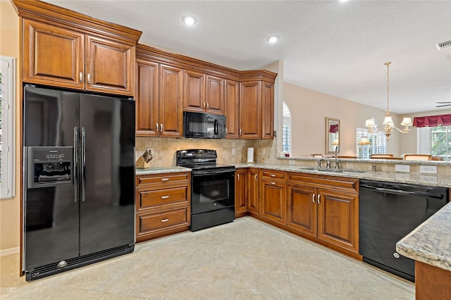 kitchen featuring light stone countertops, tasteful backsplash, black appliances, light tile floors, and a chandelier