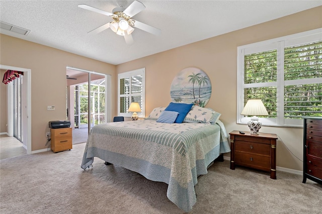 carpeted bedroom with ceiling fan, multiple windows, a textured ceiling, and access to exterior