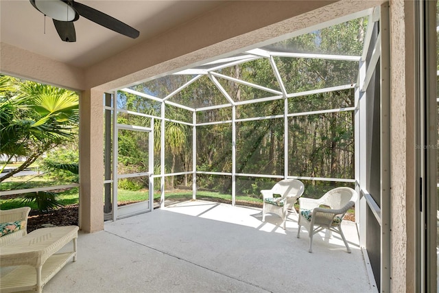 unfurnished sunroom featuring ceiling fan