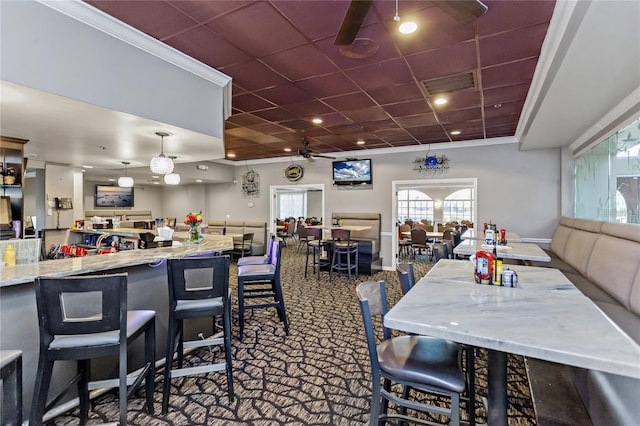 dining space featuring a drop ceiling, ceiling fan, and crown molding