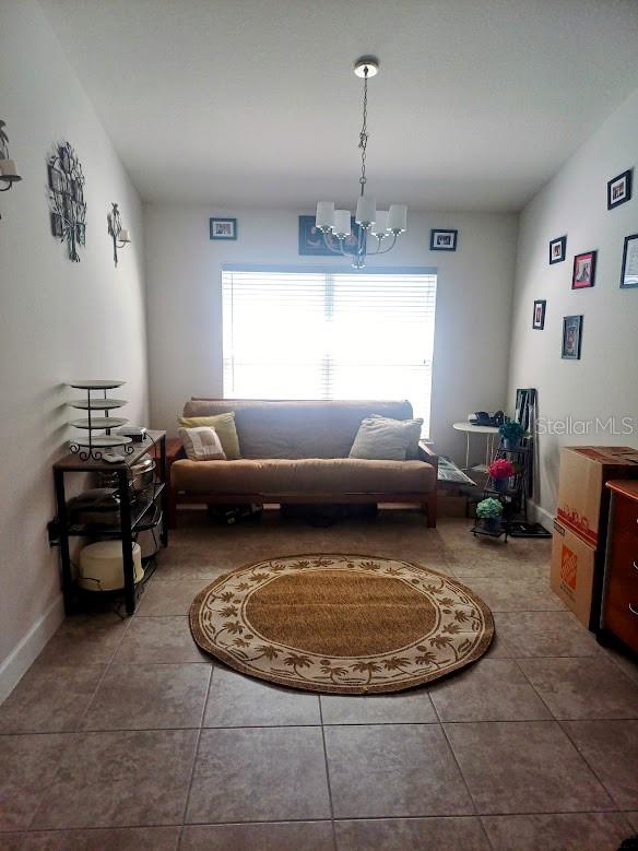 living room with a notable chandelier and tile flooring