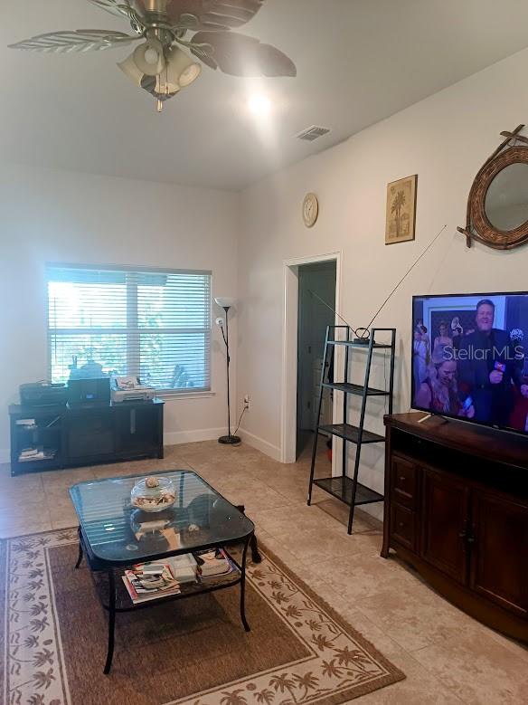 tiled living room featuring ceiling fan