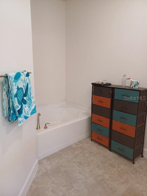 bathroom with a tub and tile floors