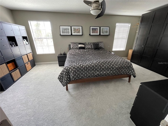 carpeted bedroom with a textured ceiling, a closet, and ceiling fan