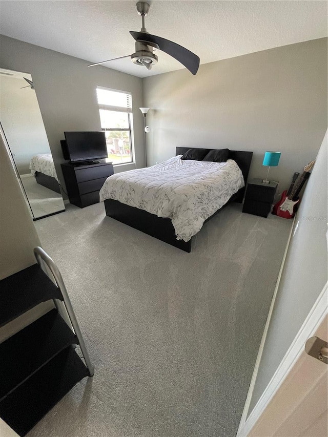 carpeted bedroom with a textured ceiling and ceiling fan