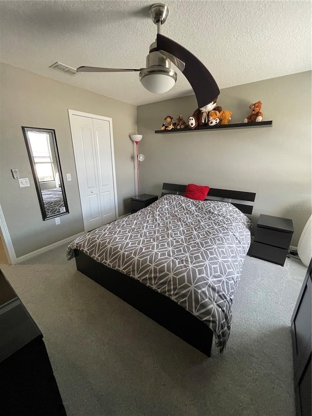 bedroom featuring a closet, a textured ceiling, carpet, and ceiling fan