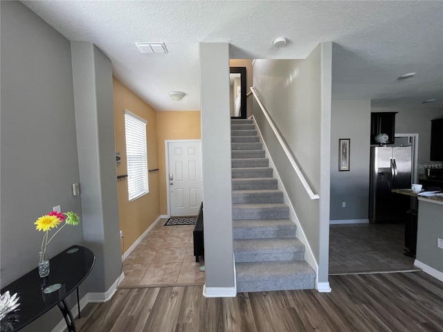 foyer entrance featuring a textured ceiling and wood-type flooring