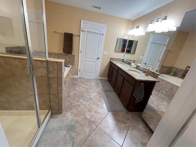 bathroom with a textured ceiling, independent shower and bath, double sink vanity, and tile flooring