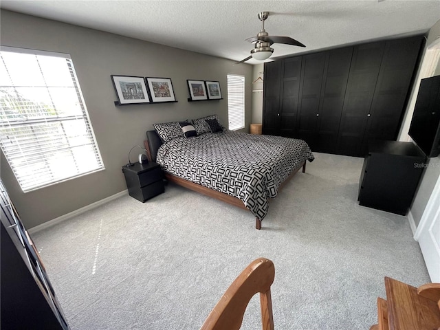 carpeted bedroom featuring a textured ceiling and ceiling fan