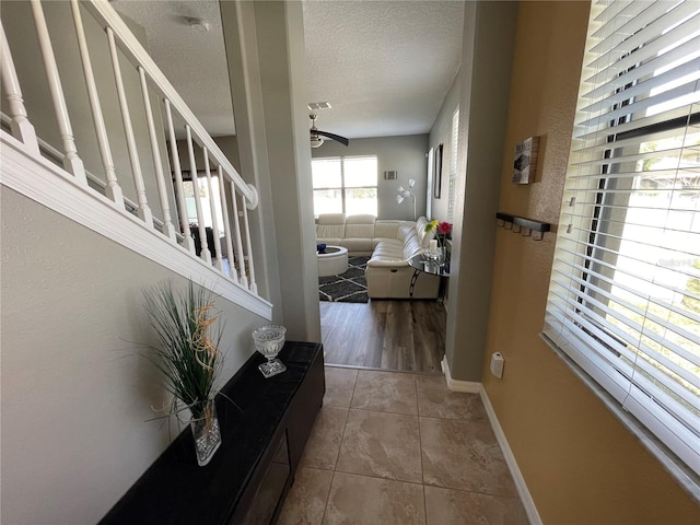 interior space with a textured ceiling and tile flooring