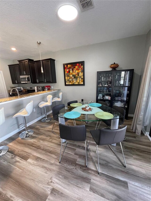 dining room featuring a textured ceiling and hardwood / wood-style flooring