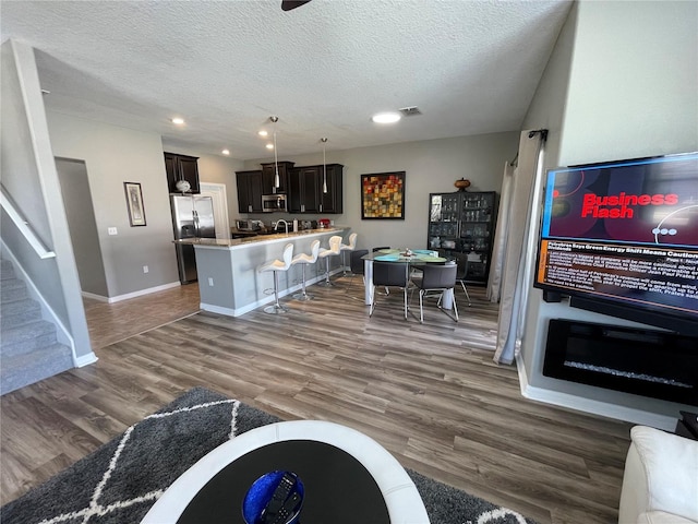 living room with a textured ceiling and dark hardwood / wood-style flooring