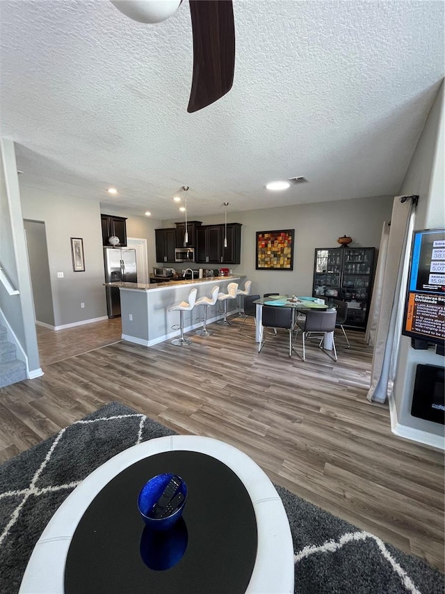 living room featuring billiards, a textured ceiling, and dark hardwood / wood-style floors